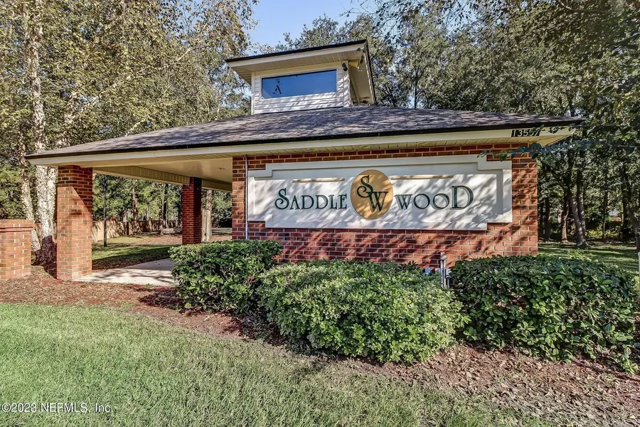 Saddlewood neighborhood entrance sign surrounded by oak trees and landscaping in Jacksonville, Florida