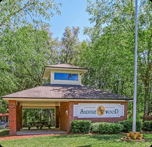 Covered picnic pavilion with the Saddlewood sign at Saddlewood Park on Saddlewood Parkway